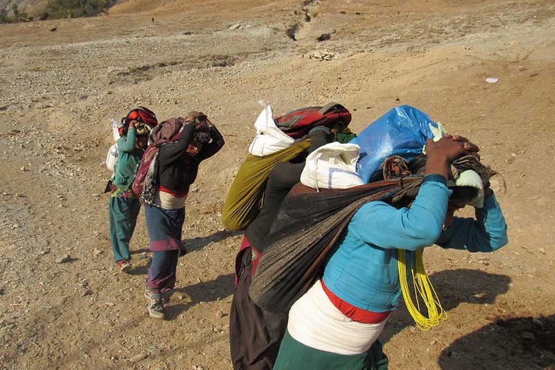 Locals heading towards their houses with bags of rice, which they bought at an exorbitant price from Kolti Bazaar in Bajura on Friday, August 21, 2020. Photo: Prakash Singh/THT