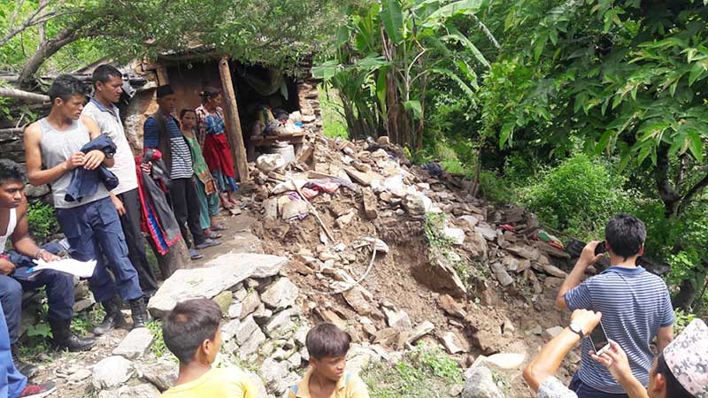 People gathering at a house that is at the risk of being swept away by landslide Budhiganga Municipality in Bajura district, on Minday, August 3, 2020. Photo: Prakash Singh/THT
