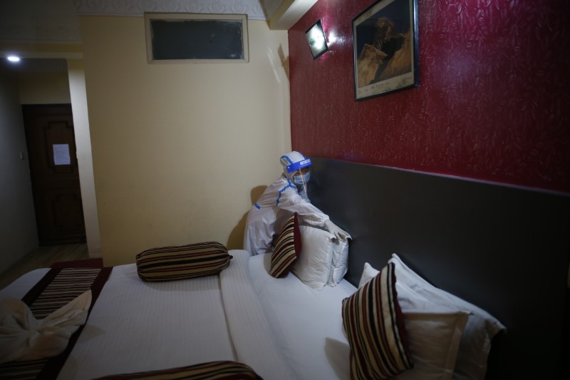 A worker wearing a personal protective suit prepares a hotel room before the reopening of the hotel, at Hotel Crown Plaza in Naxal, Kathmandu, Nepal on Sunday, August 2, 2020. Photo: Skanda Gautam/THT