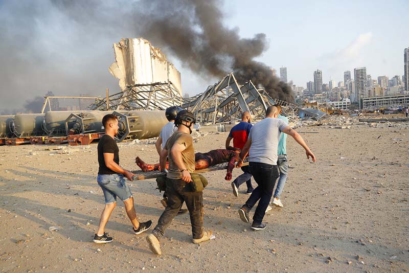 Civilians carry a victim at the explosion scene that hit the seaport, in Beirut Lebanon, on Tuesday, August 4, 2020. Photo: AP