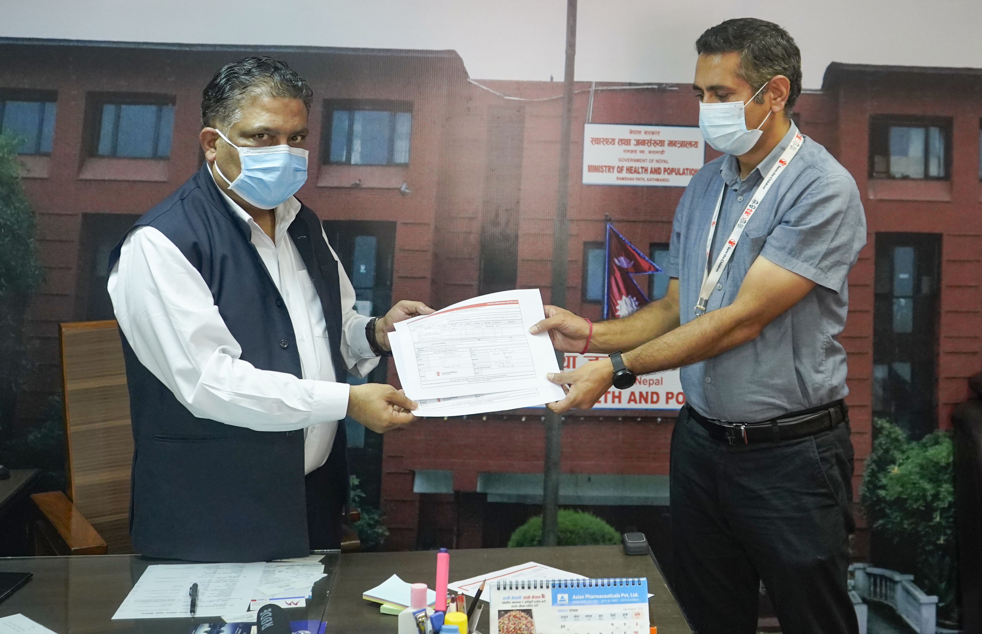 A representative from Save the Children hands over equipments to government official as a support to COVID-19 response. Courtesy: Save the Children
