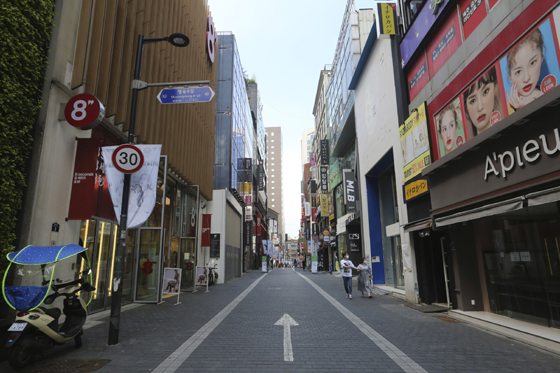A couple wearing face masks to help protect against the spread of the coronavirus walks along on a nearly empty shopping street in Seoul, South Korea, Sunday, Aug. 23, 2020. Photo: AP