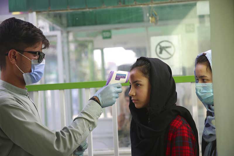 A health worker checks the temperature of visitors to help curb the spread of the coronavirus at the entrance to Kabul City Park in Kabul, Afghanistan, on Friday, July 24, 2020. Photo: AP