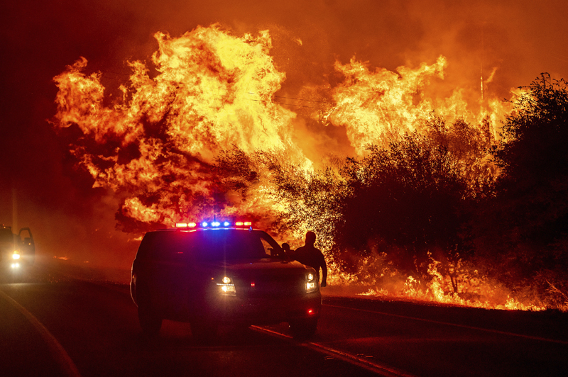 Flames lick above vehicles on Highway 162 as the Bear Fire burns in Oroville, Calif., on Wednesday, Sept. 9, 2020. Photo: AP