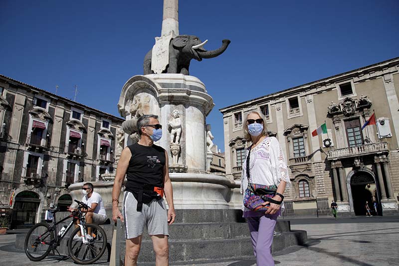 People wearing masks stand on the street after the southern Italian island of Sicily made it mandatory for masks to be worn outdoors 24 hours a day, as part of efforts to contain the coronavirus disease (COVID-19) outbreak, in Catania, Italy, on September 30, 2020. Photo: Reuters