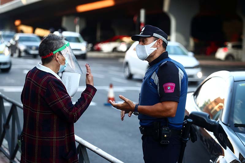 A local police officer speaks with a woman in the Vallecas neighbourhood during the first day of a partial lockdown between and within areas in six districts amid the outbreak of the coronavirus disease (COVID-19) in Madrid, Spain, on September 21, 2020. Photo: Reuters