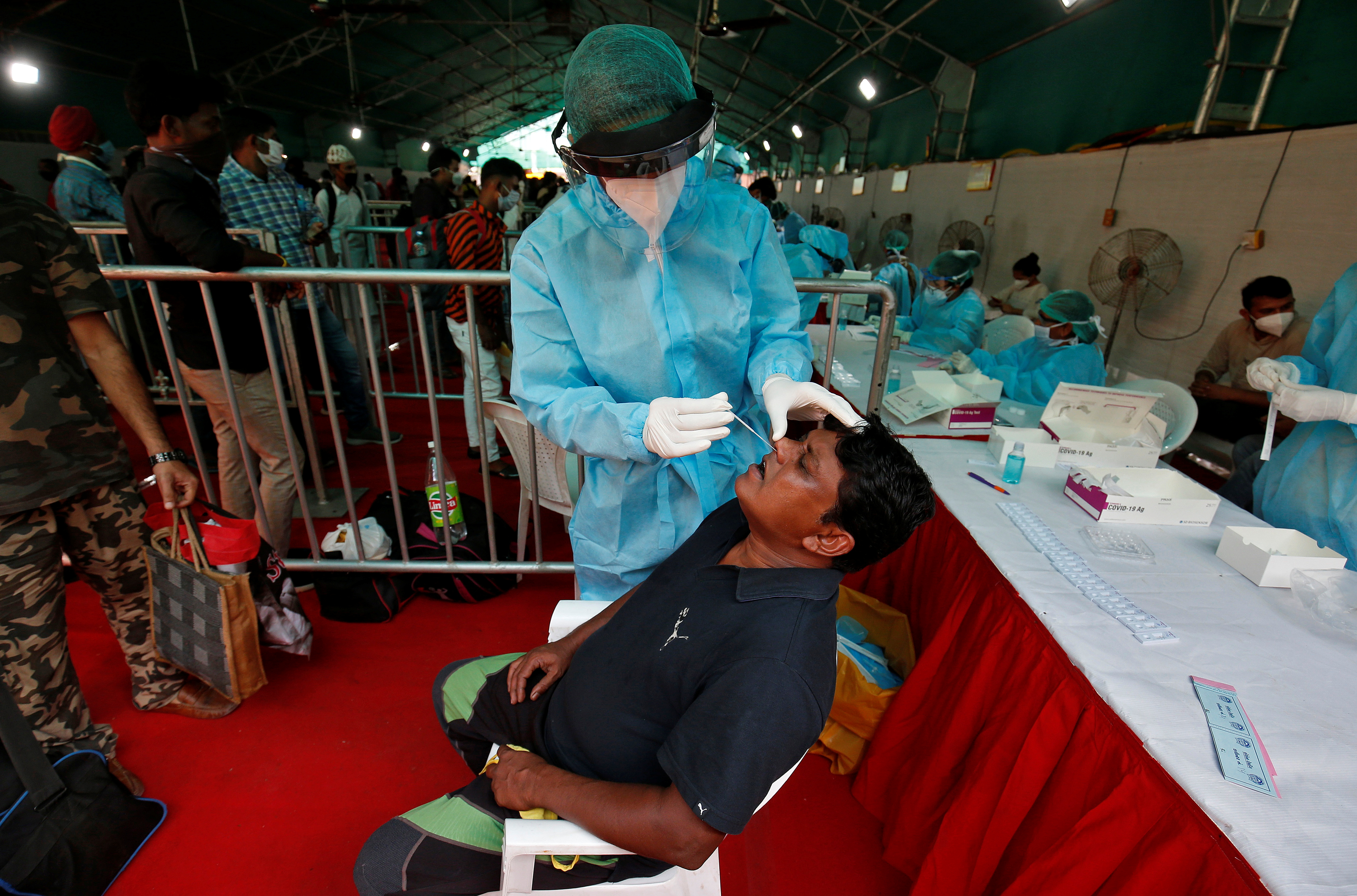 A healthcare worker collects a swab from a passenger for a rapid antigen test upon his arrival at a railway station, amidst the coronavirus disease (COVID-19) outbreak, in Ahmedabad, India, September 8, 2020. Photo: Reuters 