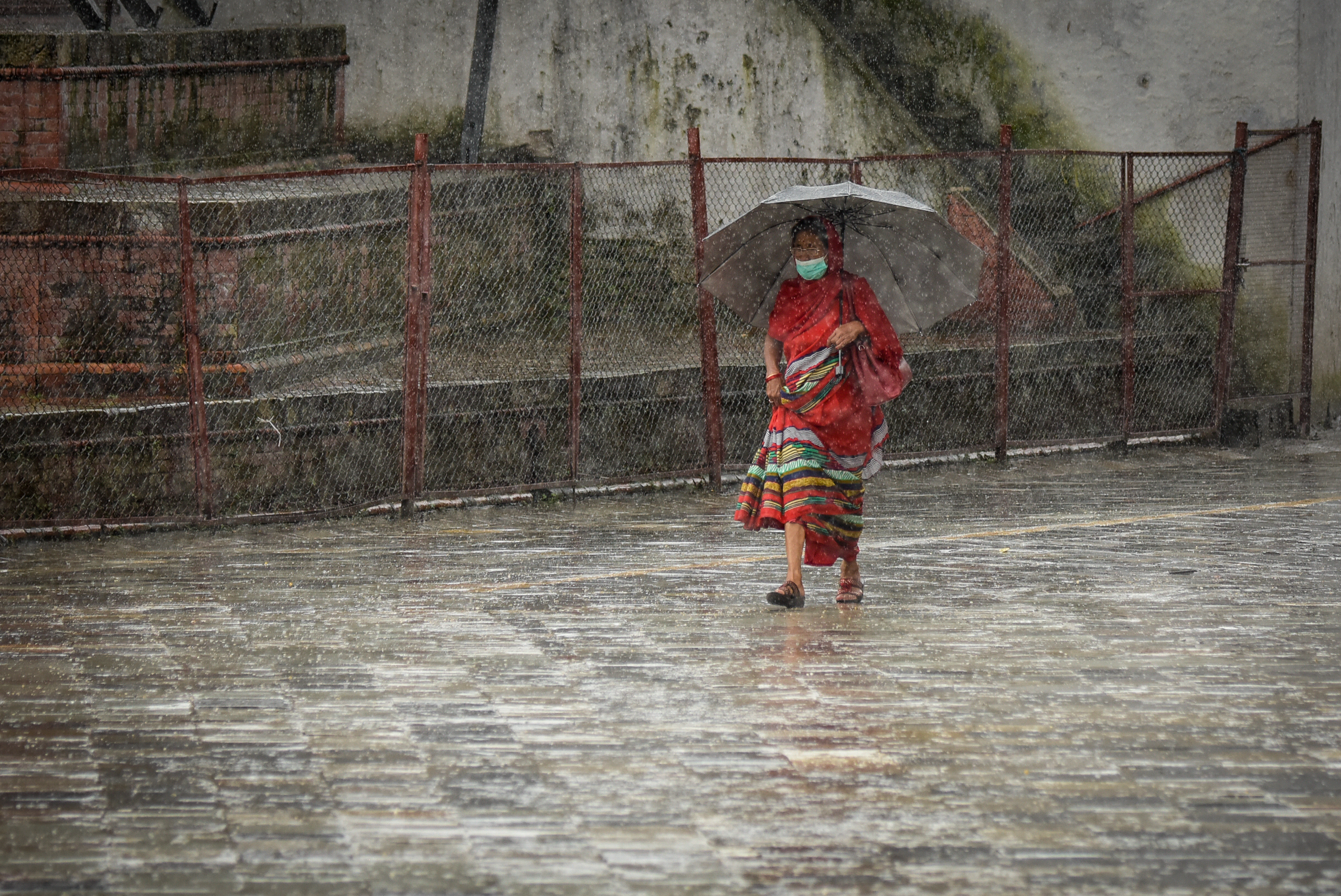 A woman with umbrella passing through Hanumandhoka durbar square during rainfall in Kathmandu on Tuesday. Photo: Naresh Shrestha