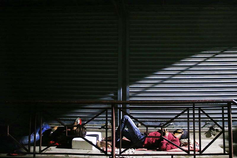 Men sleeping outside Sukraraj Tropical and Infectious Disease Hospital on Wednesday night, hoping to be the early bird in the queue for submitting swab samples in Teku, Kathmandu, in the wee hours of Thursday, September 24, 2020. Photo: Skanda Gautam / THT