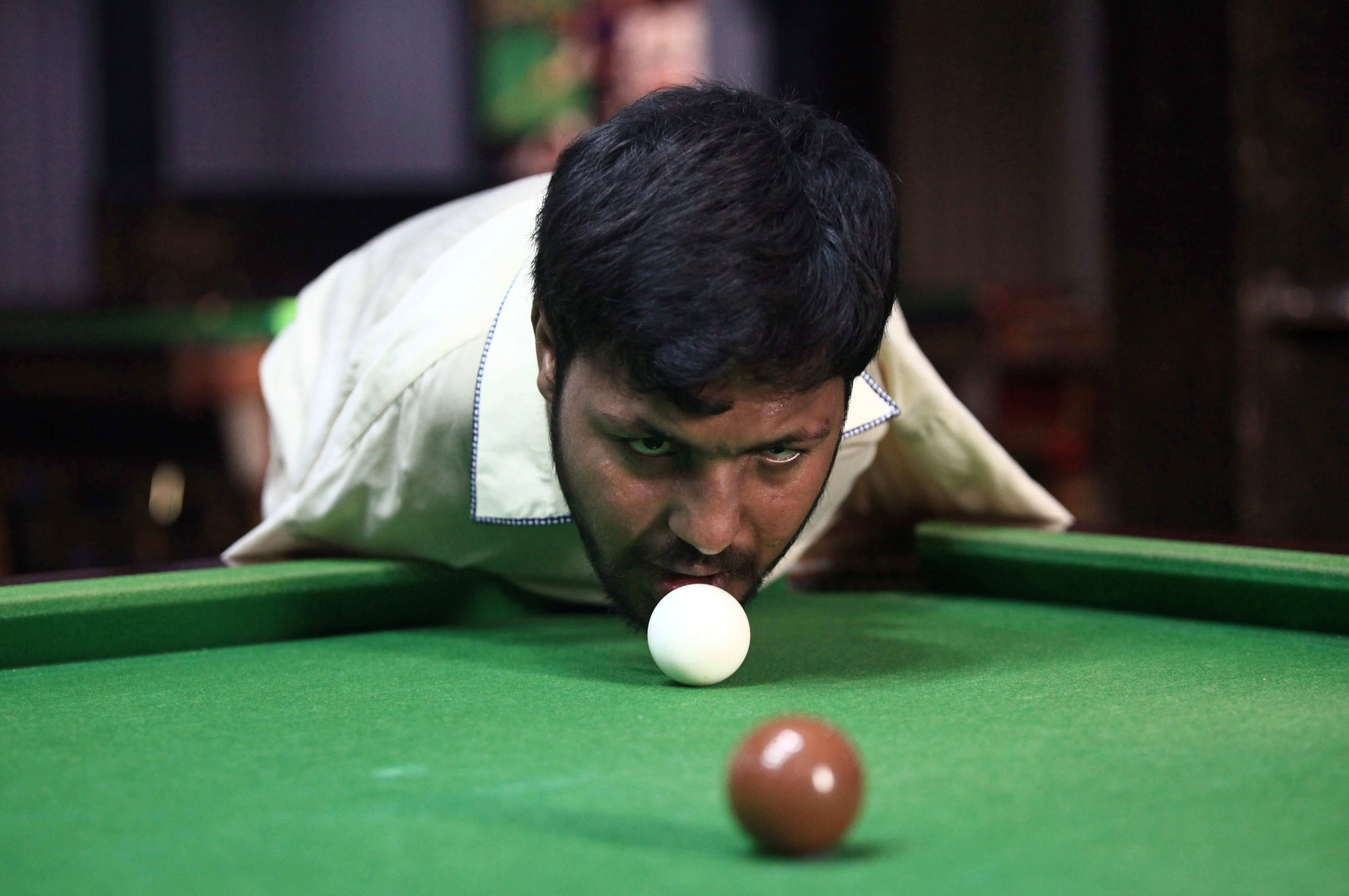 Muhammad Ikram, 32, who was born without arms, plays snooker with his chin at a local club in Samundri, Pakistan, October 20, 2020. Photo: Reuters