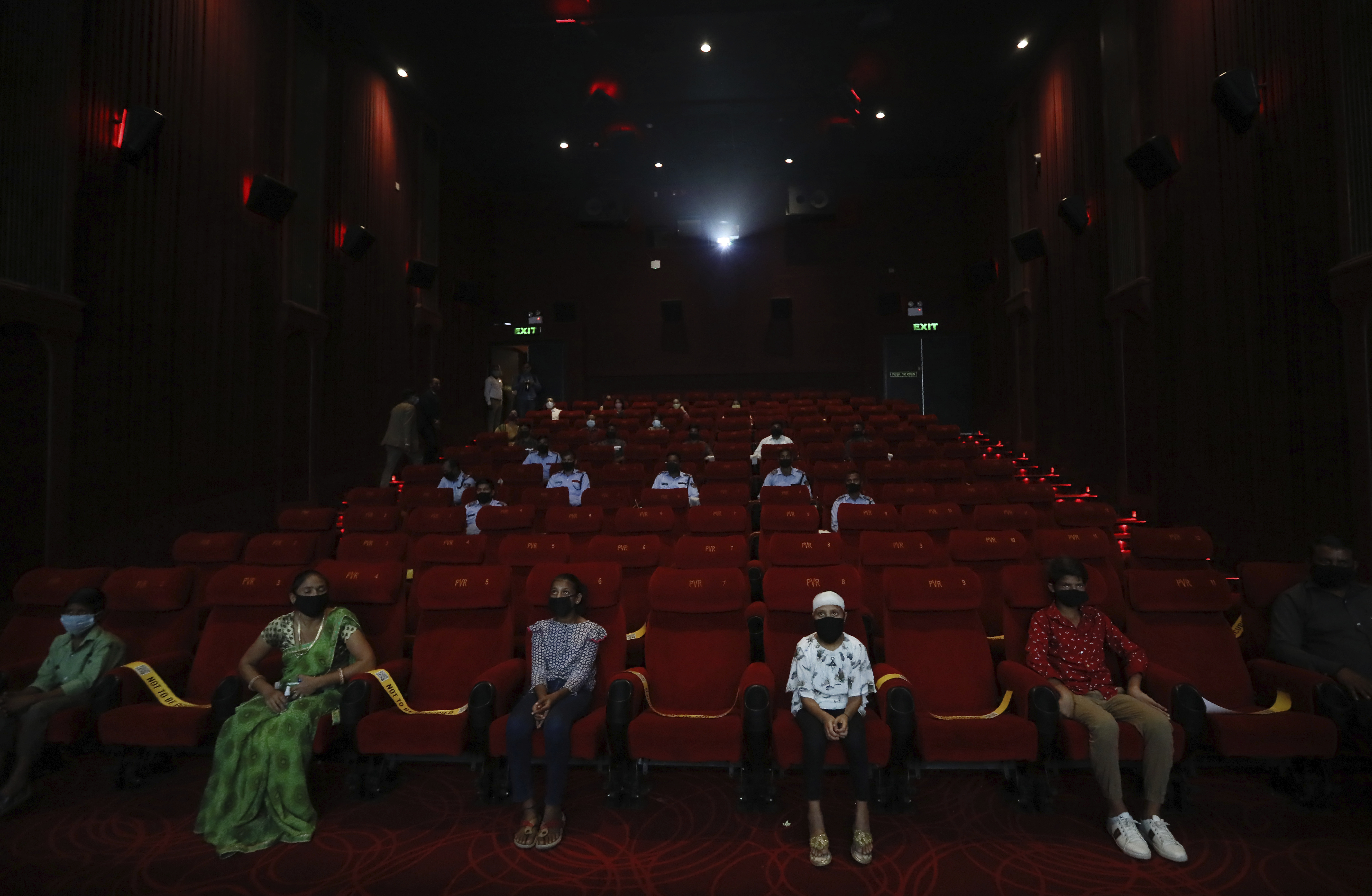 People watch an Indian Bollywood movie as cinemas reopen with a special screening for COVID- 19 warriors and their families at the PVR movie theater in New Delhi, India, Thursday, Oct. 15, 2020. Seven months after screens went dark, cinemas reopened Thursday in much of India with mostly old titles on the marquee u2014 a sign of the countryu2019s efforts to return to normal as the pace of coronavirus infections slows but also of the roadblocks that remain. (AP Photo/Manish Swarup)
