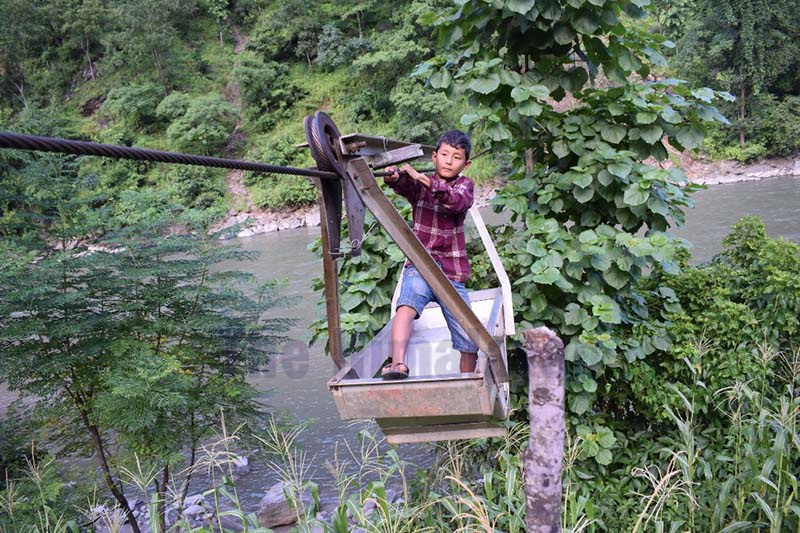 This undated image shows a boy crossing Chhedagad River by a tuin, a rope bridge that connects Saltada of Shhivalaya Rural Municipality-1 and Karkigaun of Chhedagad Municipality-12 in Jajarkot district.