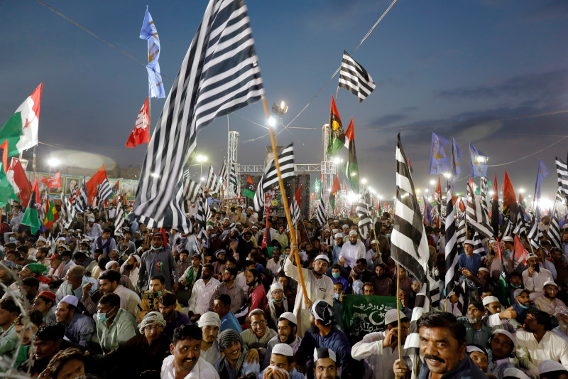 Supporters of Pakistan Democratic Movement (PDM), an alliance of political opposition parties, wave flags as they listen to their leaders during an anti-government protest rally in Karachi, Pakistan October 18, 2020. Photo: Reuters