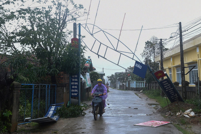 A man bikes past a broken sign as the Typhoon Molave lashes Vietnam's coast in Binh Chau village, Quang Ngai province October 28, 2020. Photo: Reuters