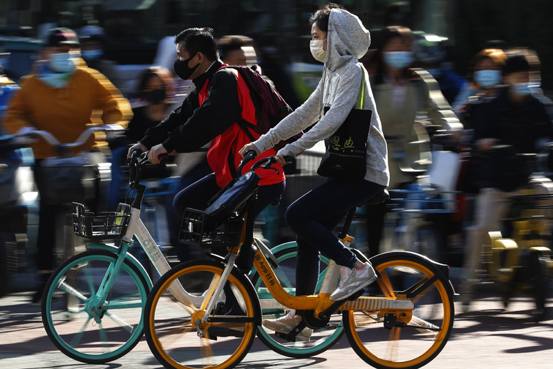 People wearing face masks to help curb the spread of the coronavirus ride bicycle during the morning rush hour in Beijing, Monday, Oct. 12, 2020. Photo: AP
