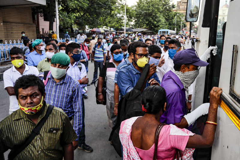 Commuters wearing masks board a long distance bus in Kolkata, India, Thursday, Oct. 1, 2020. Photo: AP