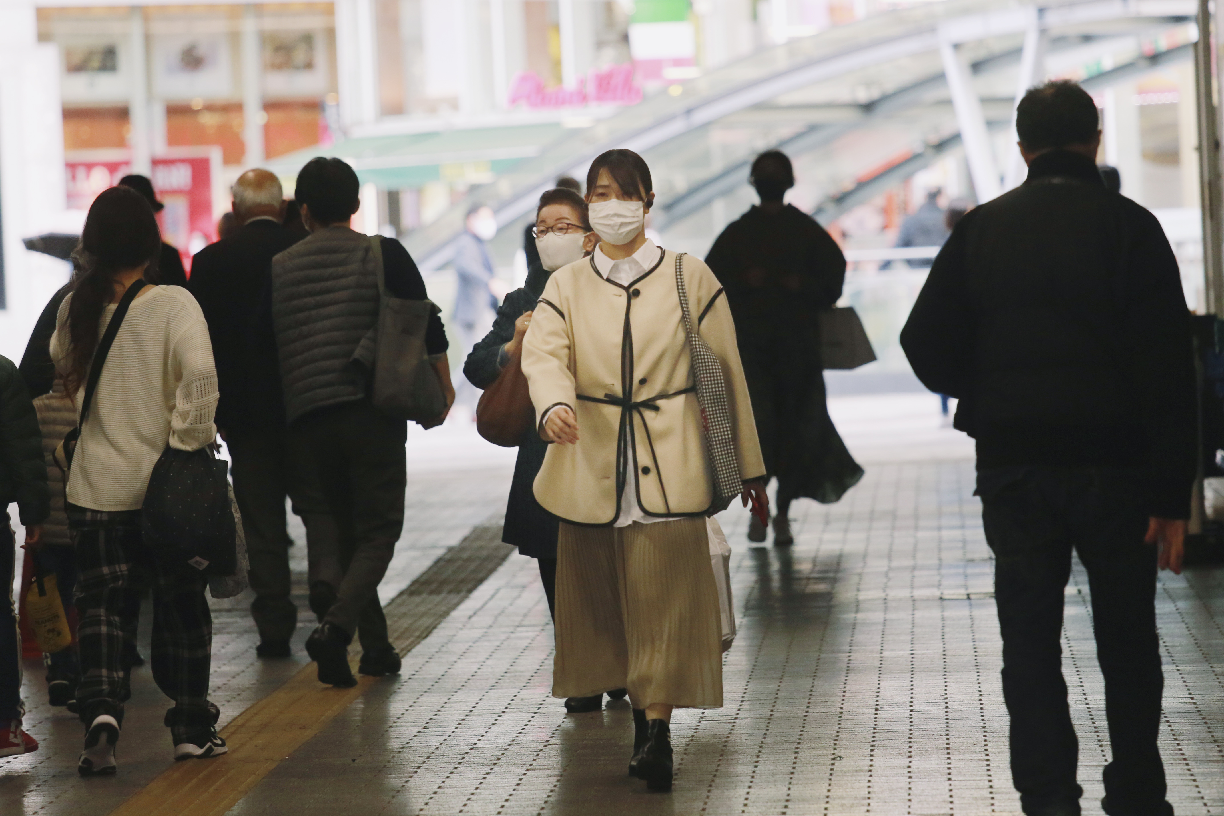 People wearing face masks to help curb the spread of the coronavirus walk underpass in Tokyo, Wednesday, Nov. 18, 2020. Photo: AP