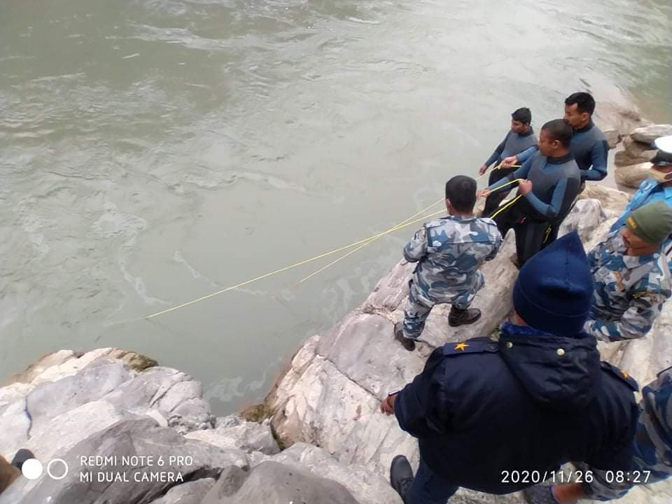 Security personnel observing the incident site where a pickup van plunged into Trishuli River at Ichchhakamana Rural Municipality-4 of Chitwan district, as pictured on Thursday, November 26, 2020. Photo Courtesy: Chitwan Police