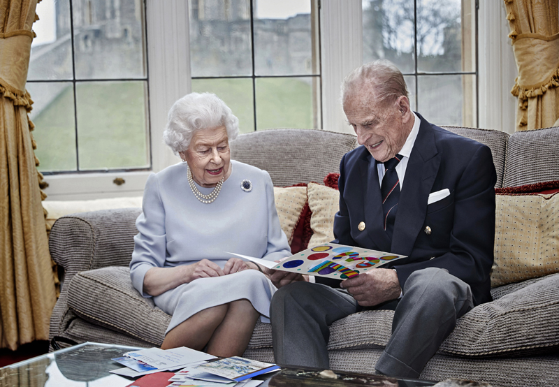 In this image released on Thursday Nov. 19, 2020, Britain's Queen Elizabeth II and Prince Philip, Duke of Edinburgh look at a homemade wedding anniversary card, given to them by their great grandchildren Prince George, Princess Charlotte and Prince Louis, as the royal couple sit in the Oak Room at Windsor Castle, England, Nov. 17, 2020, ahead of their 73rd wedding anniversary. Photo: Chris Jackson/Pool via AP
