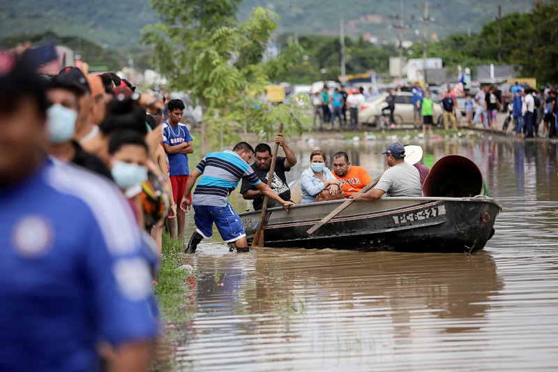 People board a boat to get to their flooded house during the passage of Storm Eta, in Pimienta, Honduras November 5, 2020.  Photo: Reuters