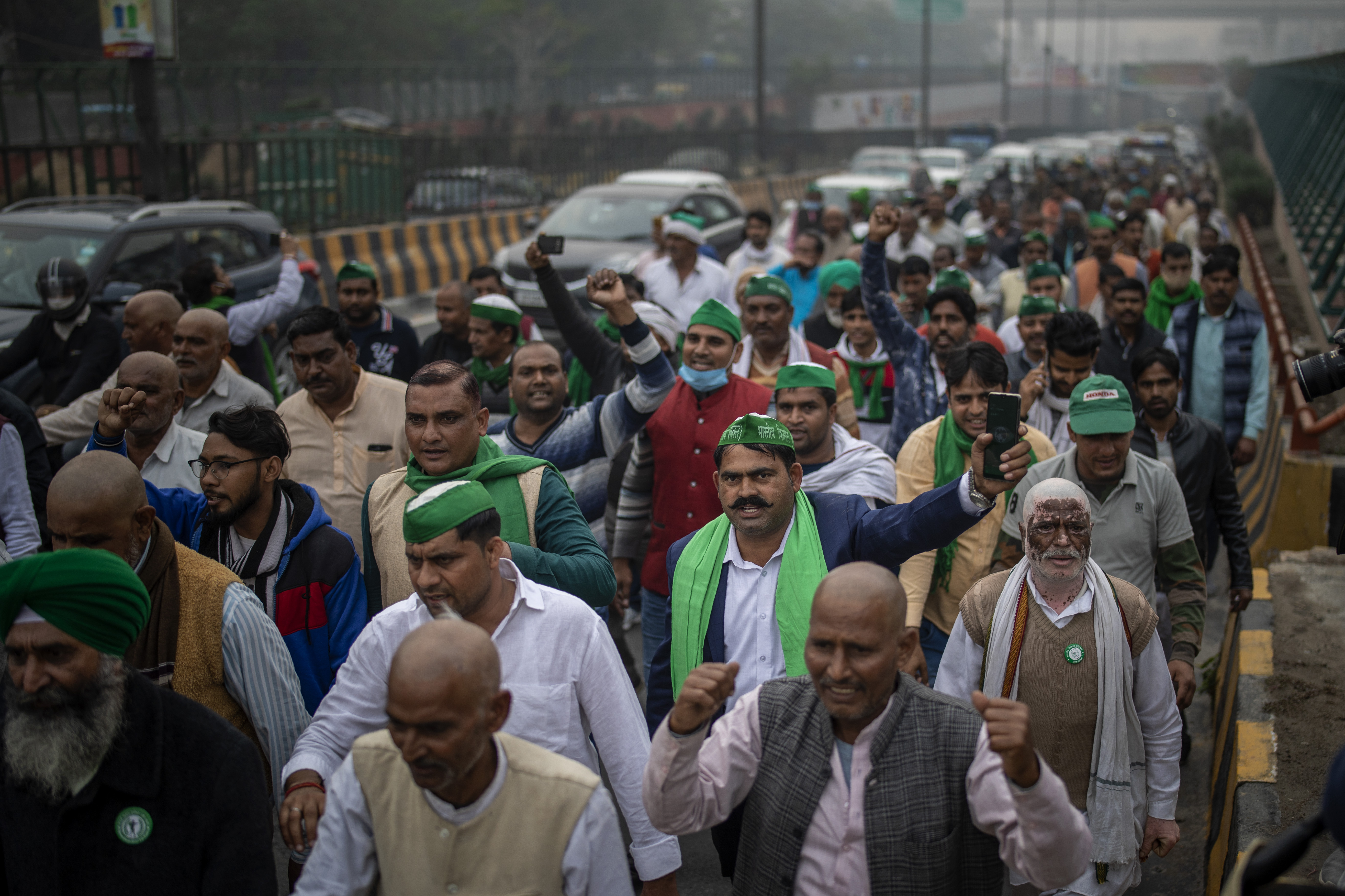 A group of protesting farmers march towards the residence of ruling Bhartiya Janata Party leader Mahesh Sharma to hand over a list of their demands during a protest against new farm in Noida on the outskirts of New Delhi, India, Saturday, Dec. 12, 2020. Indian farmers filed a petition with the Supreme Court on Friday seeking the quashing of three new laws on agricultural reform which they say will drive down crop prices, as they continued their two-week blockade of highways connecting to the Indian capital. Photo: AP