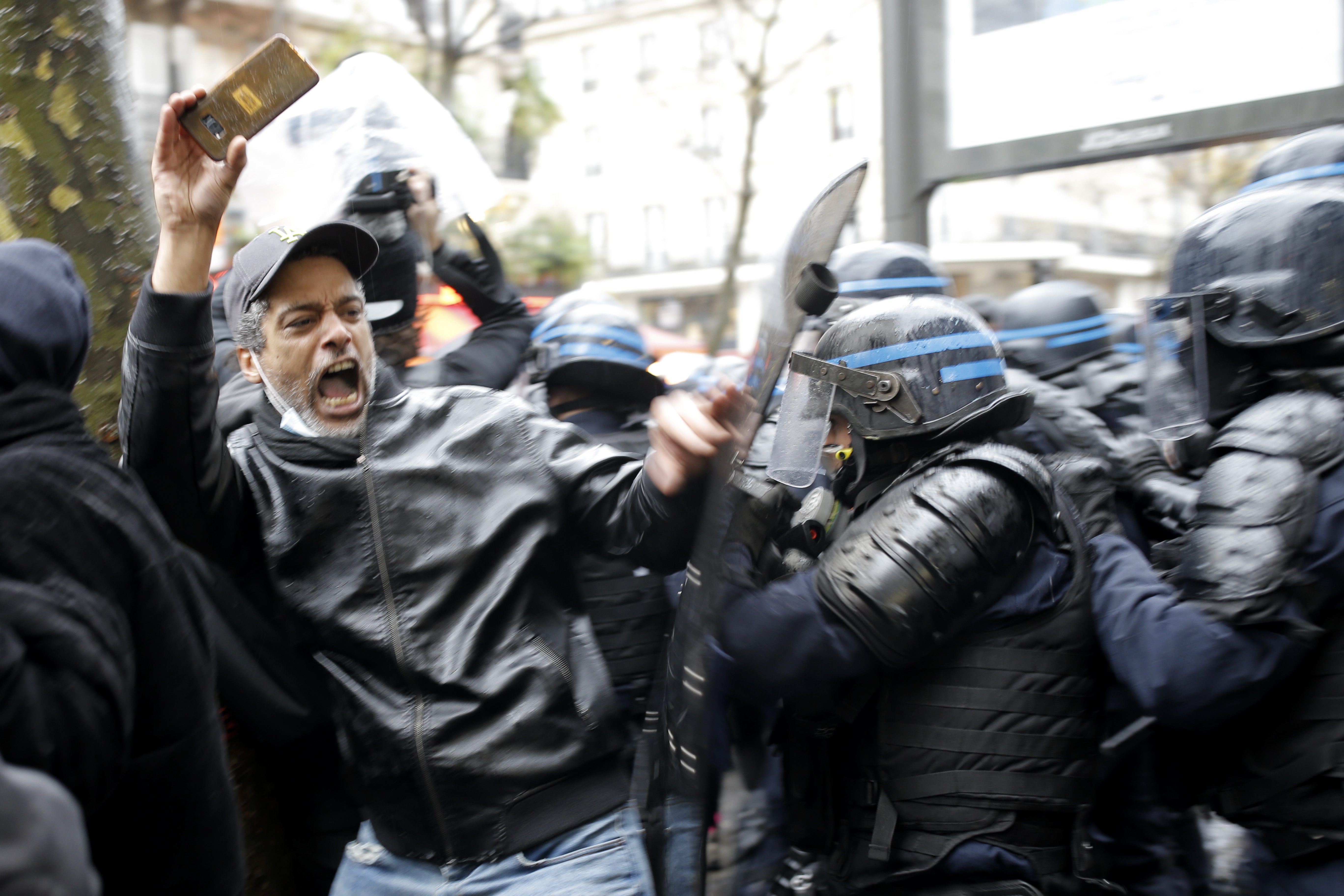 Riot police officers charge a man holding his phone during a protest, Saturday, Dec.12, 2020 in Paris. Protests are planned in France against a proposed bill that could make it more difficult for witnesses to film police officers. Photo: AP