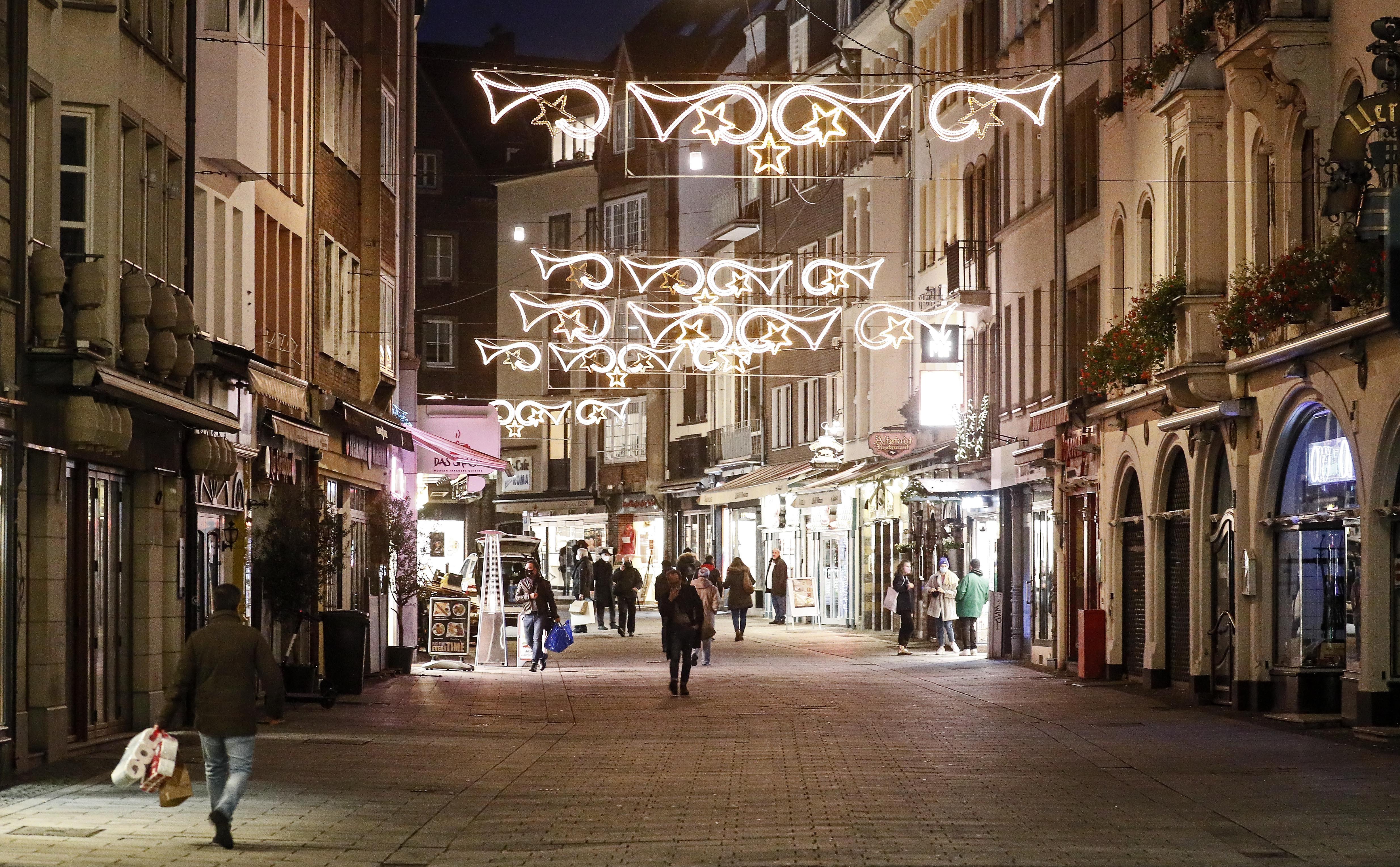 Christmas lights shine over a virtually empty shopping street in the old town of Duesseldorf, Germany, on Monday afternoon, Dec. 14, 2020. Chancellor Angela Merkel and the governors of Germanyu2019s 16 states agreed Sunday to step up the countryu2019s lockdown measures beginning Wednesday and running to Jan. 10 to stop the exponential rise of COVID-19 cases. Photo: AP