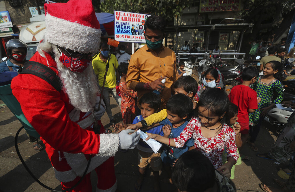 A man dressed as Santa Claus distributes masks to children in Dharavi, one of Asia's biggest slums, in Mumbai, India, Saturday, December 19, 2020. Photo: AP