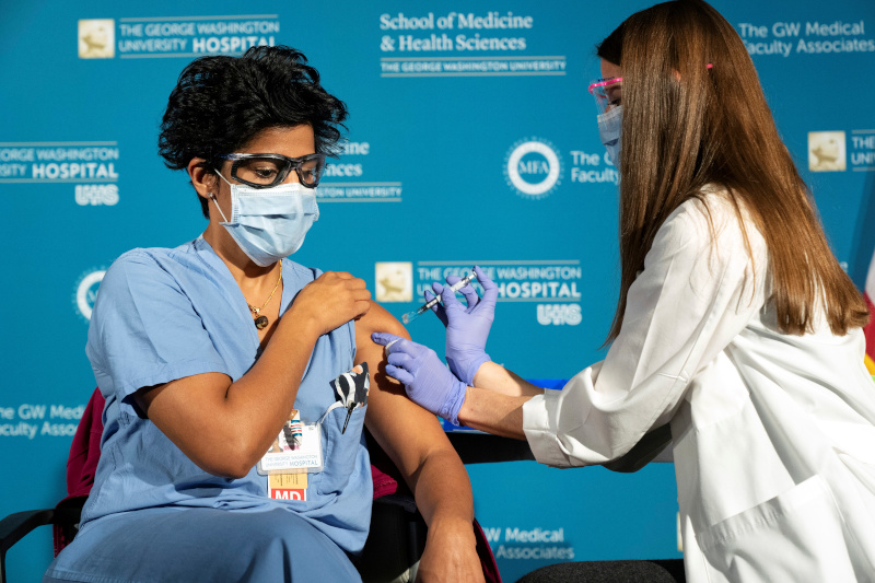 Dr. Sheetal Sheth, an OB-GYN and Medical Director for Labor and Delivery at George Washington University Hospital, is vaccinated for COVID-19 by nurse Lillian Wirpsza in Washington, D.C., U.S. December 14, 2020. Photo: Jacquelyn Martin/Pool via Reuters