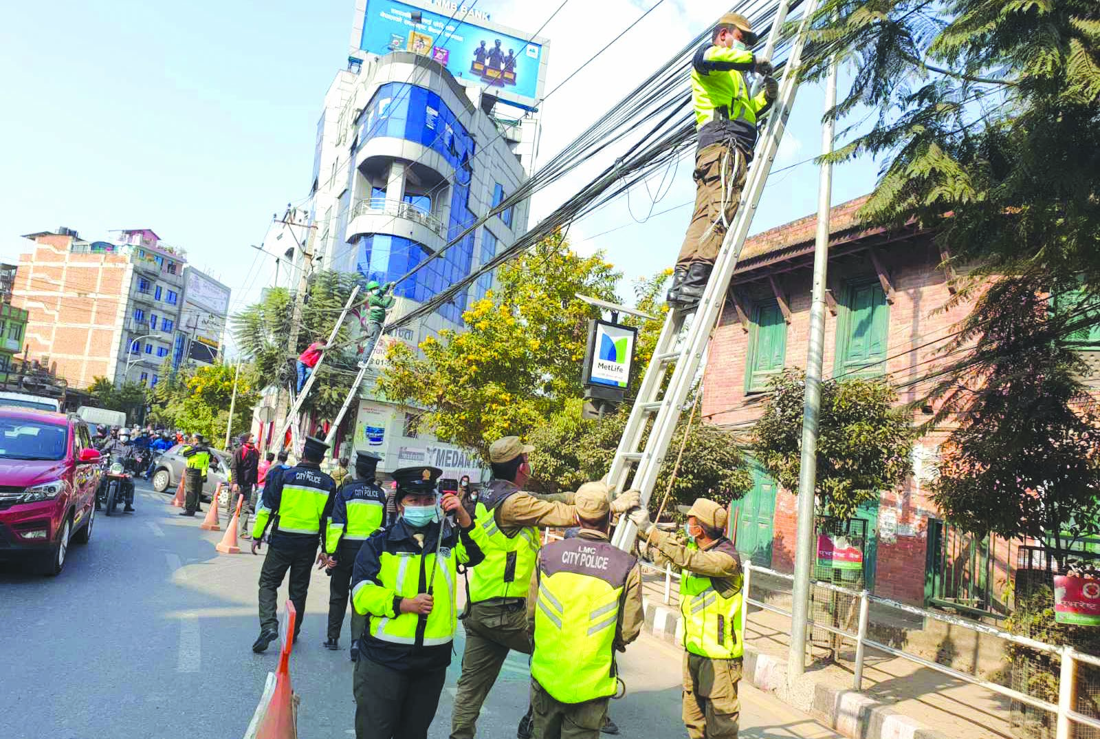 Lalitpur Metropolitan City police managing wires and cables dangling from utility poles in major city areas inside the metropolis, on Sunday. Photo: THTn