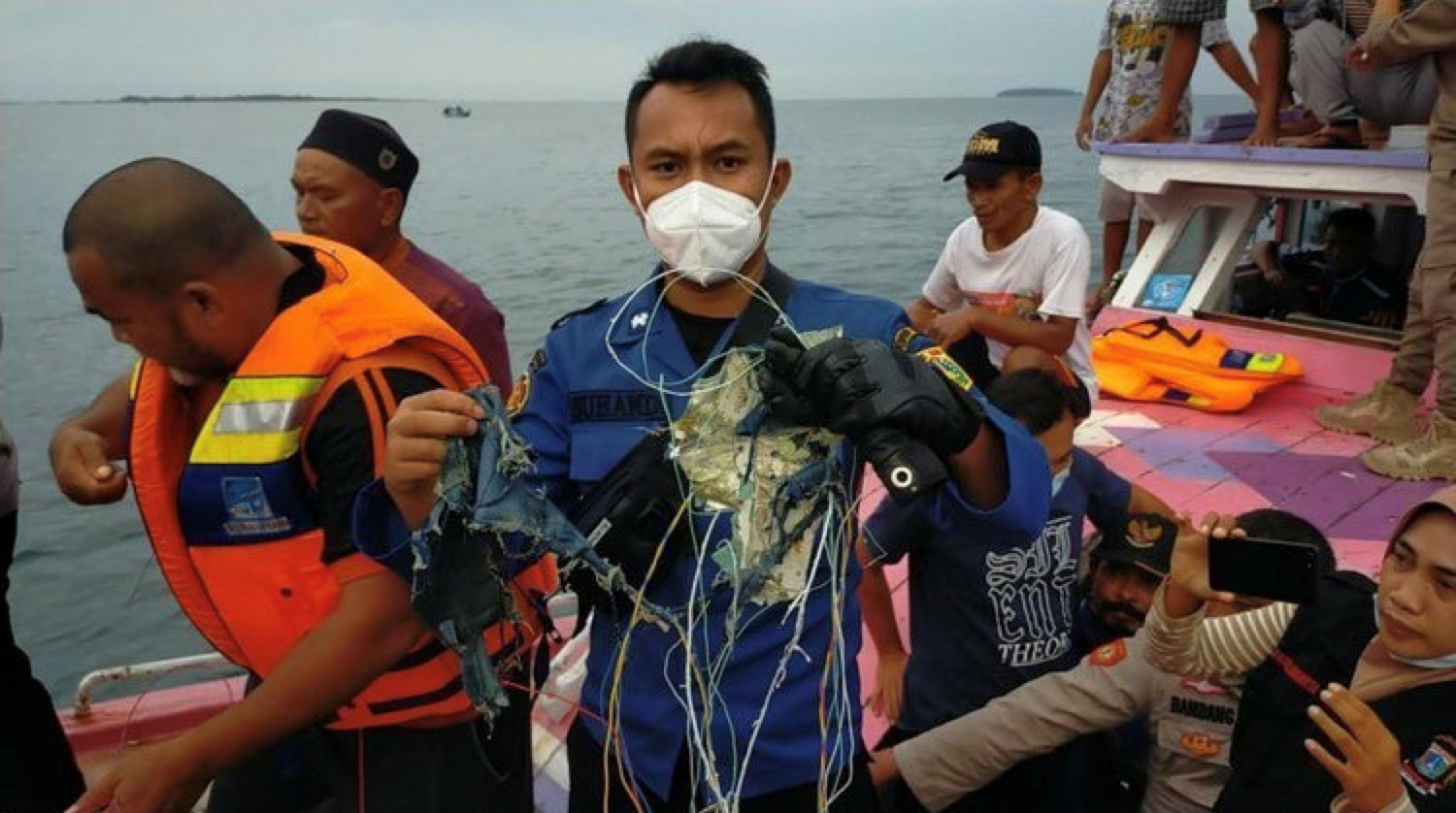 A member of the rescue team looking for an Indonesian plane that lost contact after taking off from the capital Jakarta holds suspected debris, at sea, January 9, 2021, in this picture obtained from social media. Photo: Reuters
