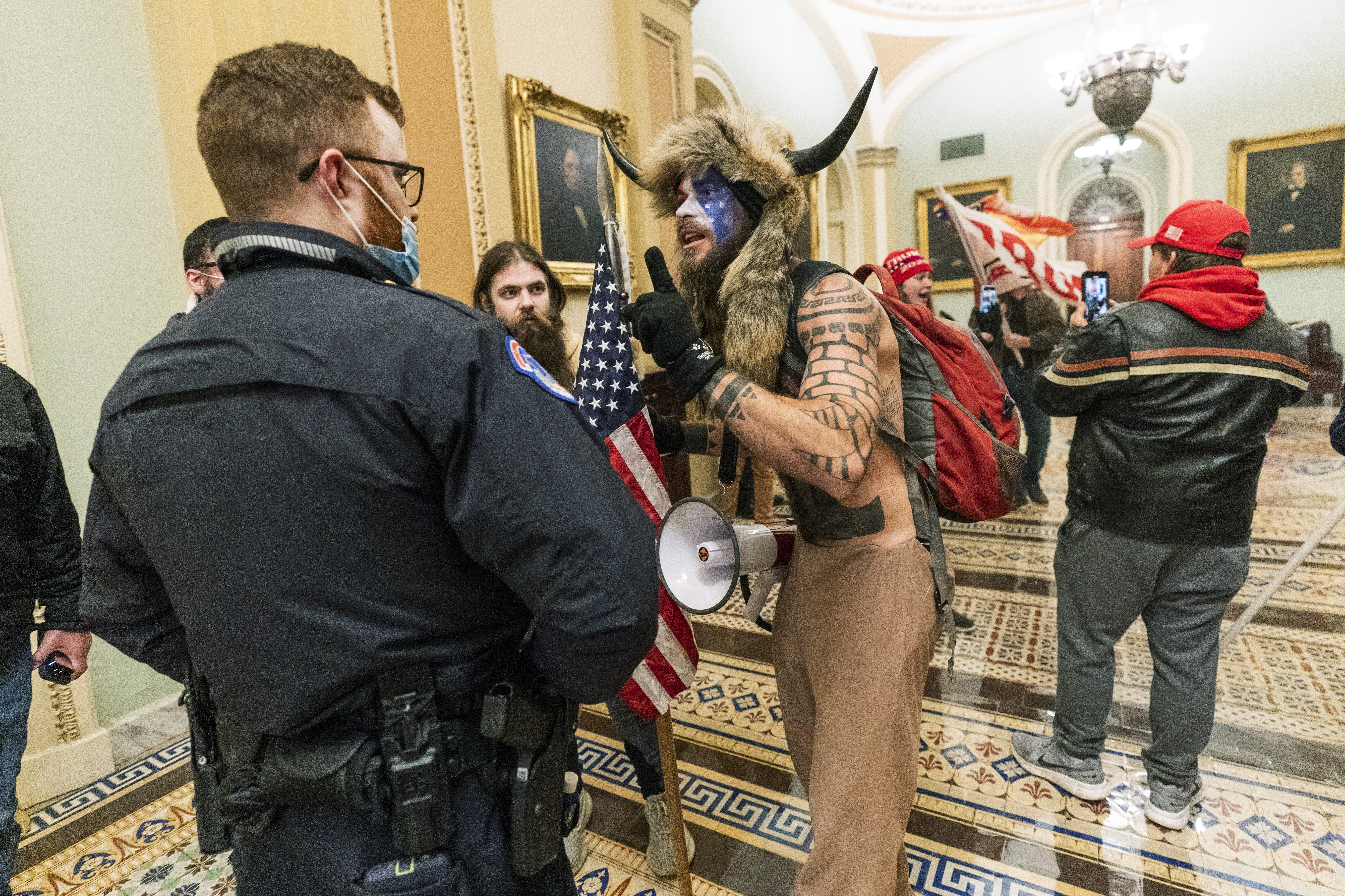 FILE - In this Jan. 6, 2021, file photo supporters of President Donald Trump are confronted by U.S. Capitol Police officers outside the Senate Chamber inside the Capitol in Washington. An Arizona man seen in photos and video of the mob wearing a fur hat with horns was also charged Saturday in Wednesday's chaos. Jacob Anthony Chansley, who also goes by the name Jake Angeli, was taken into custody Saturday, Jan. 9. Photo: AP