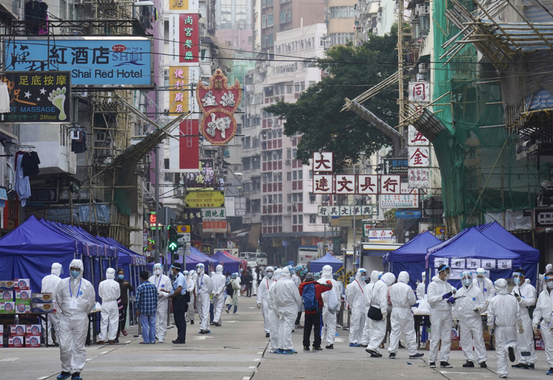 Government investigators wearing protective suits gather in the Yau Ma Tei area in Hong Kong, Saturday, Jan. 23, 2021. Photo: AP