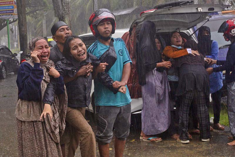 People react as the body of a relative is retrieved from the ruin of a building at an area affected by an earthquake in Mamuju, West Sulawesi, Indonesia, on Friday, January 15, 2021. Photo: AP