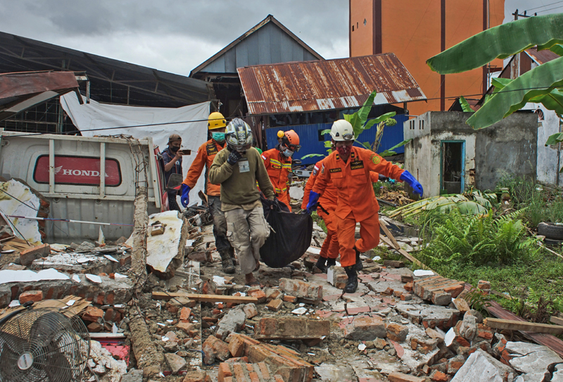 Rescuers carry a body bag containing a victim of an earthquake in Mamuju, West Sulawesi, Indonesia, Friday, Jan. 15, 2021. Photo: AP