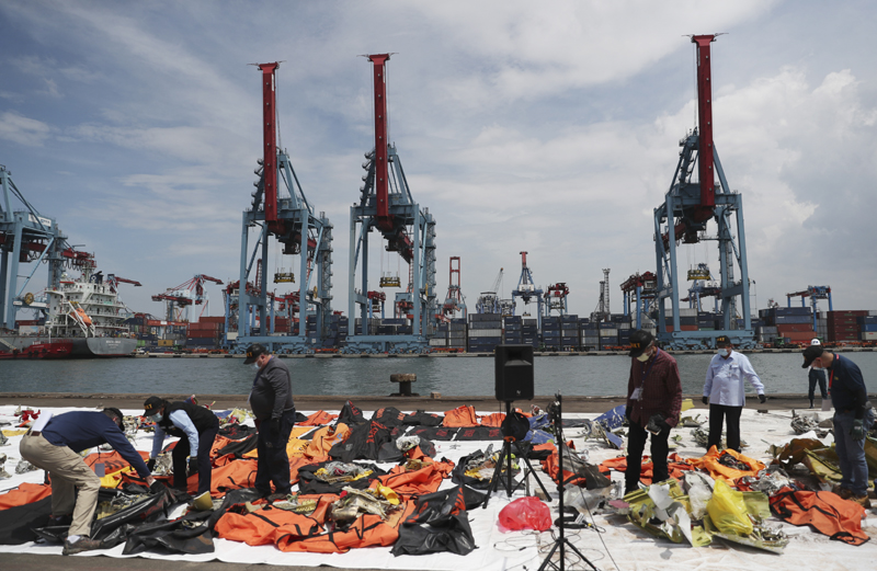 Investigators from Indonesian National Transportation Safety Committee (KNKT) and U.S. National Transportation Safety Board (NTSB) inspect debris found in the waters around the location where a Sriwijaya Air passenger jet crashed, at the search and rescue command center at Tanjung Priok Port in Jakarta, Indonesia Saturday, Jan. 16, 2021. Photo: AP