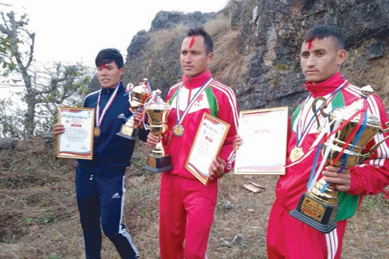 Tribhuvan Army Club athlete Rajan Rokaya (centre) displays trophy and letter of appreciation in Damauli, Rishing Rural Municipality, Tanahun district, on Monday, January 11, 2021. Rokaya won the title of the first Open Marathon organised by the rural municipality. Photo: THT