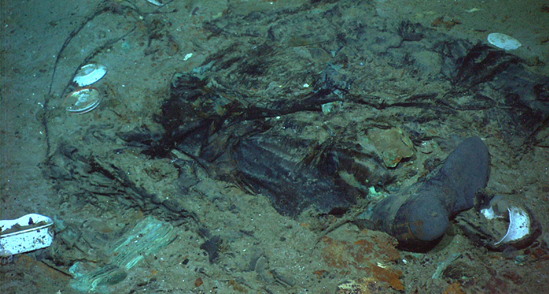 This 2004 photo provided by the Institute for Exploration, Center for Archaeological Oceanography/University of Rhode Island/NOAA Office of Ocean Exploration, shows the remains of a coat and boots in the mud on the sea bed near the Titanic's stern. Fallout from the coronavirus pandemic is threatening a companyu0092s plans to retrieve and exhibit the radio that had broadcast distress calls from the sinking vessel, according to a court filing made by the firm on Monday, Jan. 11, 2021. Photo: (Institute for Exploration, Center for Archaeological Oceanography/University of Rhode Island/NOAA Office of Ocean Exploration