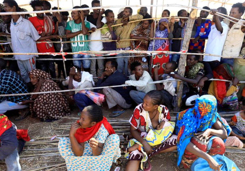 FILE PHOTO: Ethiopians who fled the ongoing fighting in Tigray region gather to receive relief aid at the Um-Rakoba camp on the Sudan-Ethiopia border, in Kassala state, Sudan December 17, 2020. Photo: Reuters